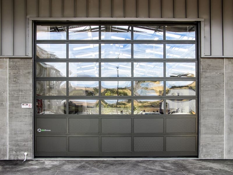A large glazed sectional door installed in a concrete and metal building.